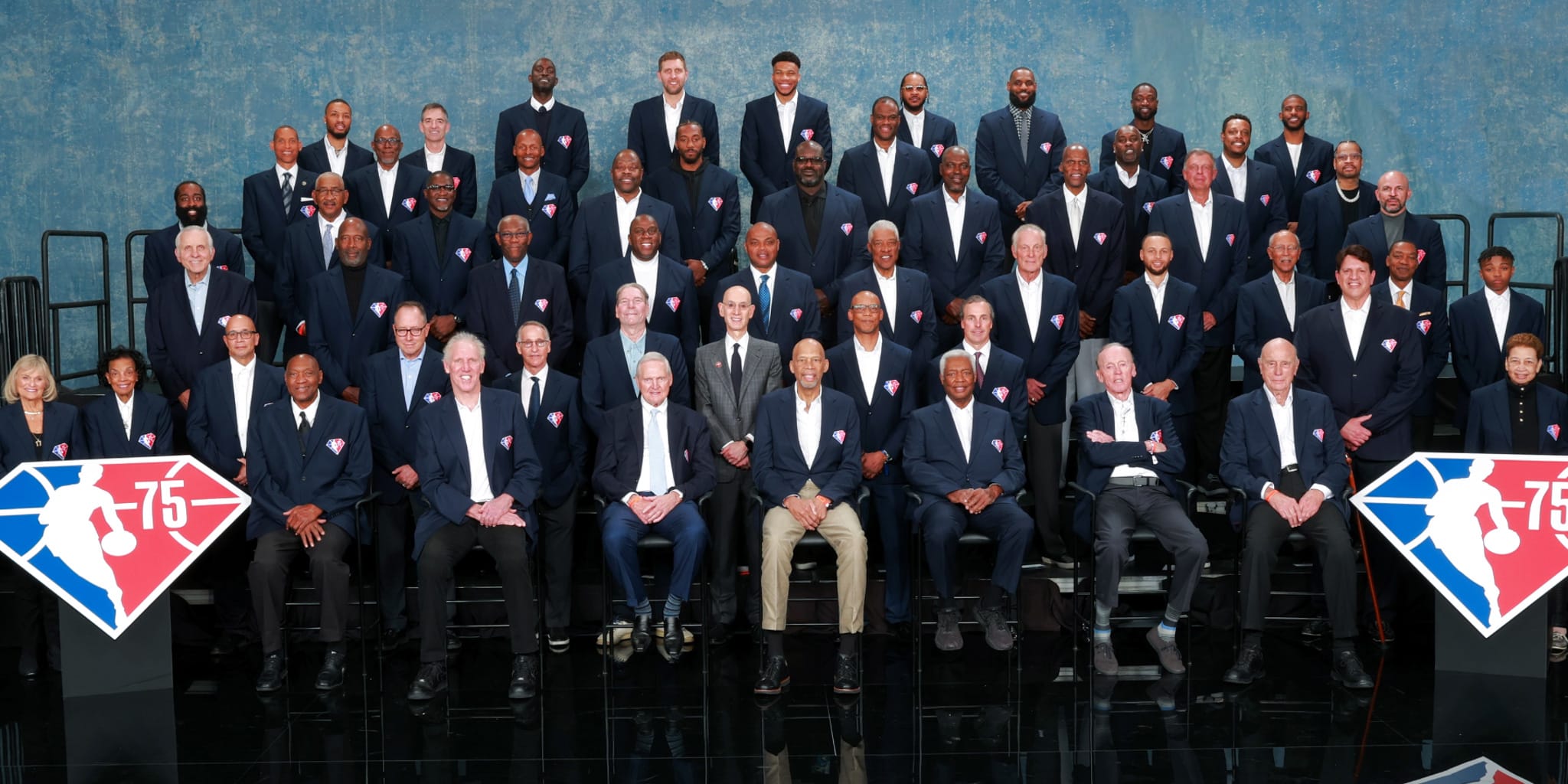 Current and former NBA legends wearing navy blue blazers, much like a class picture