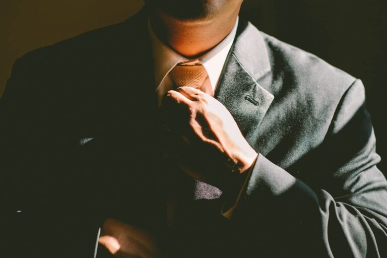 Tailor adjusting tie of suit on mannequin