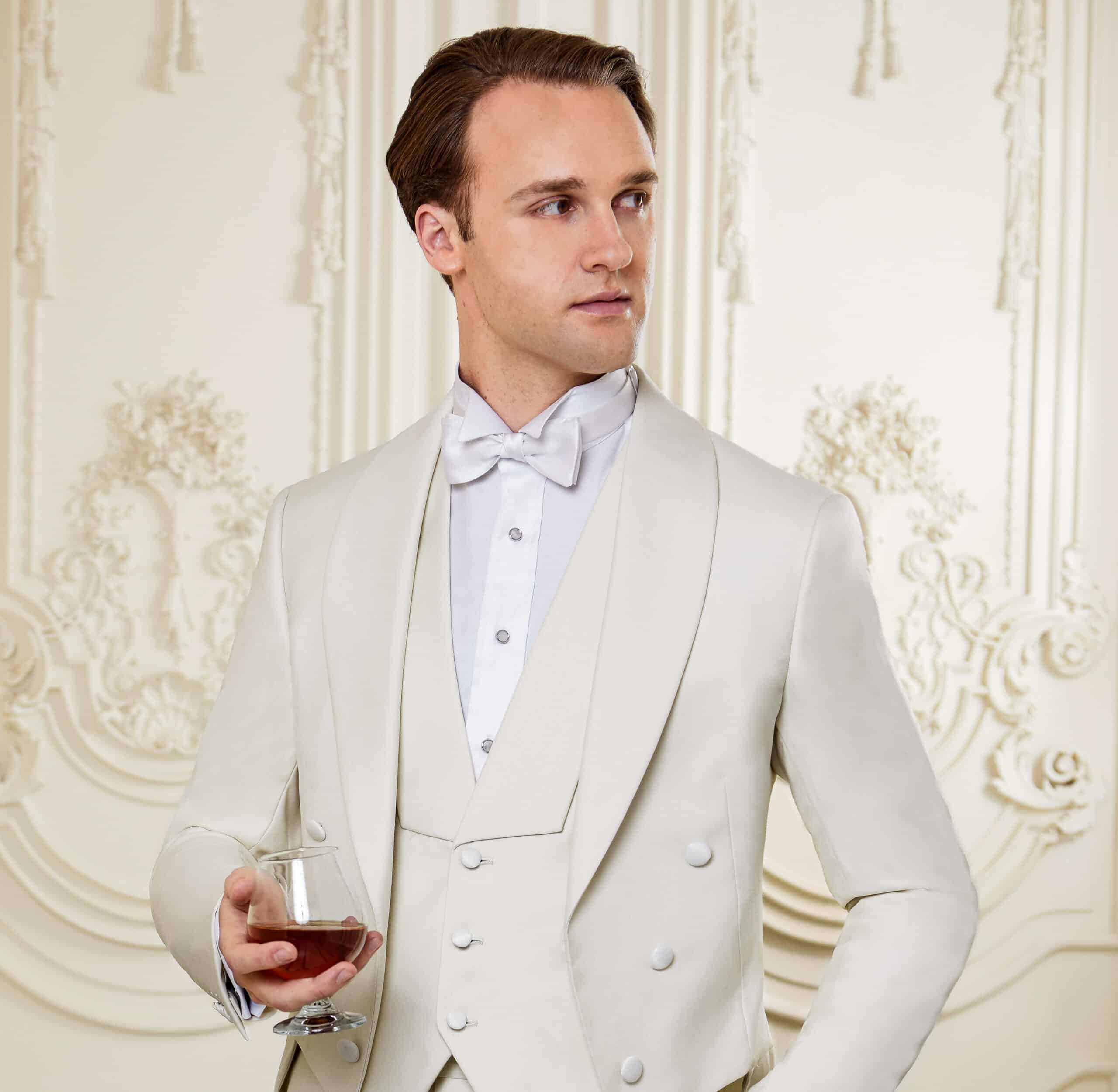 Model wearing white tails suit with matching vest. Jacket with shawl lapel, vest with cut in shawl lapel.