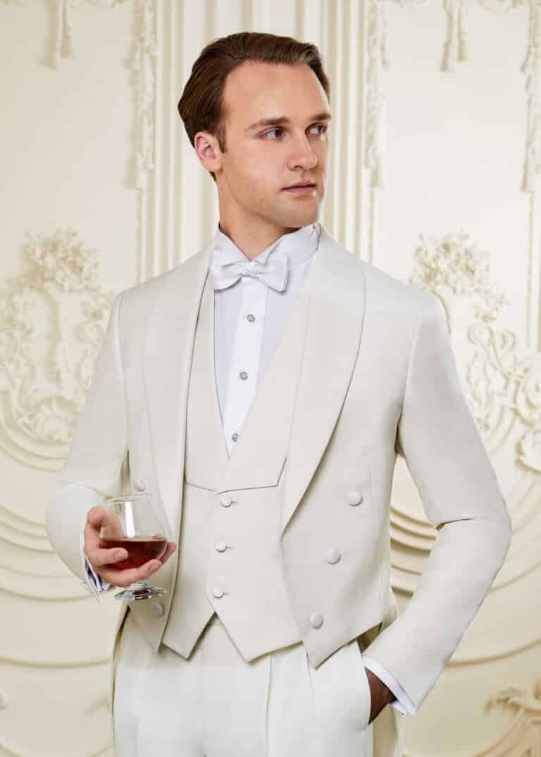 Model wearing white tails suit with matching vest. Jacket with shawl lapel, vest with cut in shawl lapel.