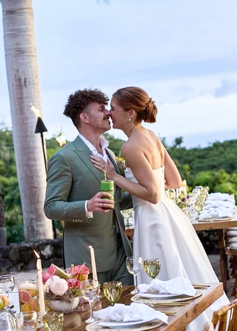 Bride and groom getting ready to kiss. Groom in light green bespoke wedding suit. Bride in wedding gown.