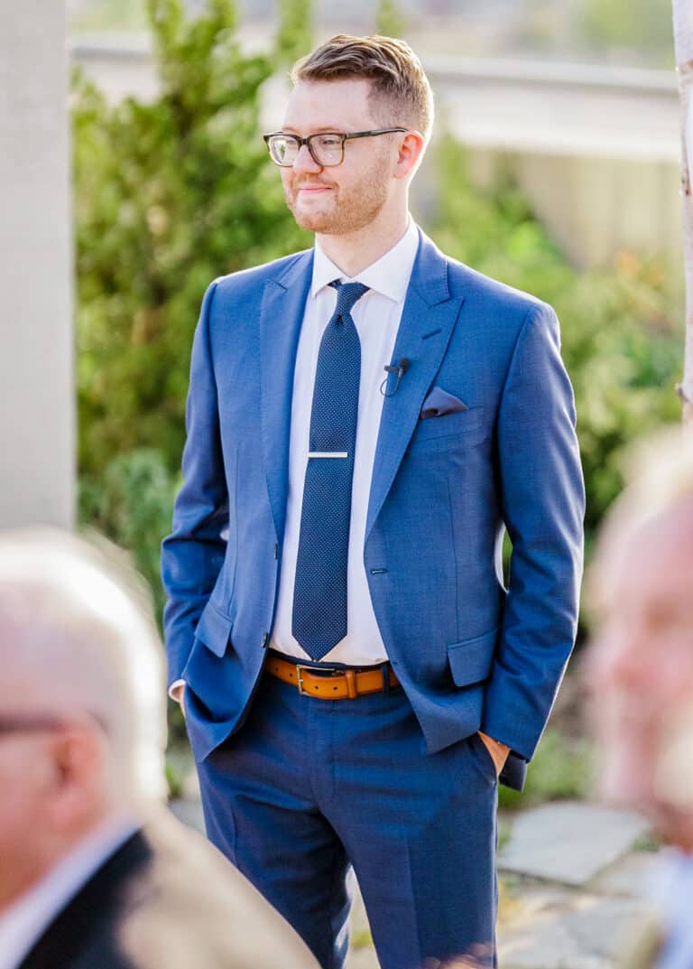 Groom outdoors wearing a blue Ermenegildo Zegna custom suit with a white shirt and a blue tie.