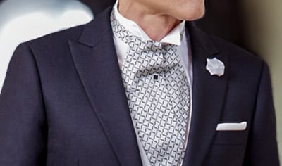 Black bespoke tuxedo full dress tails with white pique vest and shirt and black bowtie.