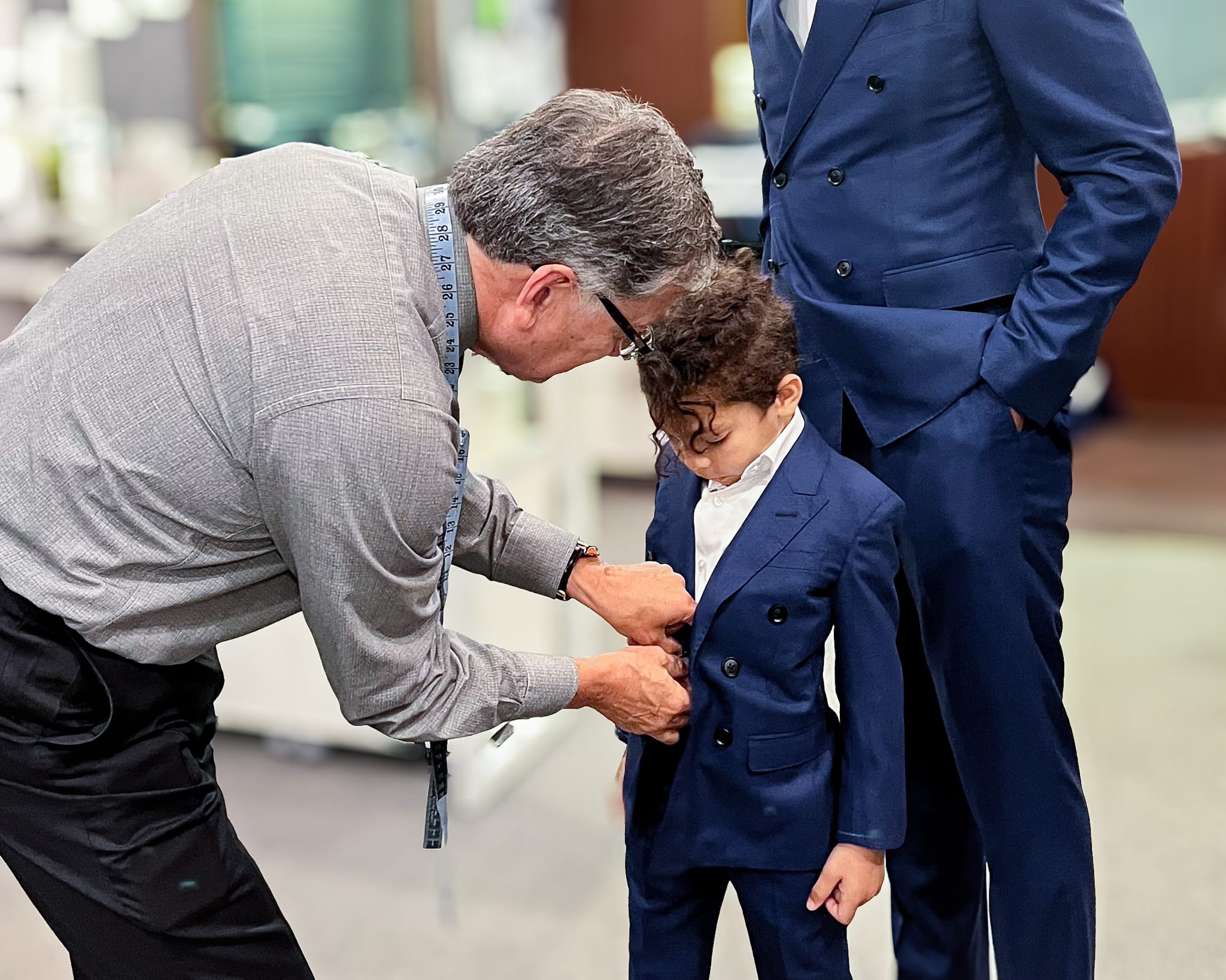 Tailor adjusting boys custom suit.