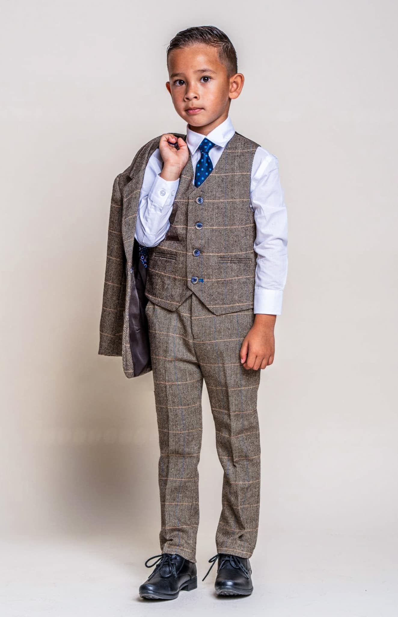 Boy in light grey vested bespoke suit.
