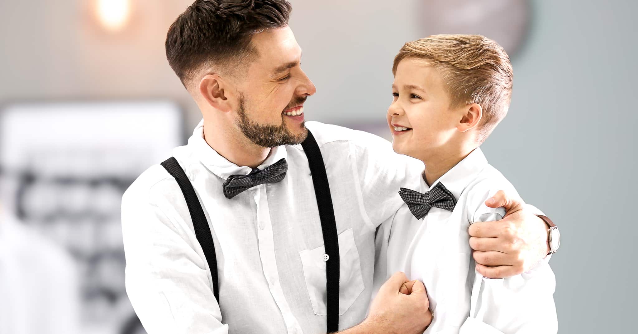 Father and son in white custom shirts and black tick bowties.