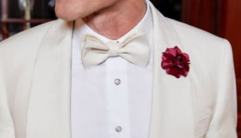 White custom tuxedo jacket with wide shawl lapel white dress shirt and white bowtie.