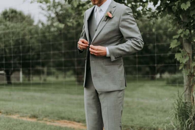 Client buttoning light green bespoke suit.