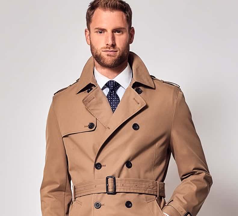 Client in light brown double breasted bespoke raincoat with belt.