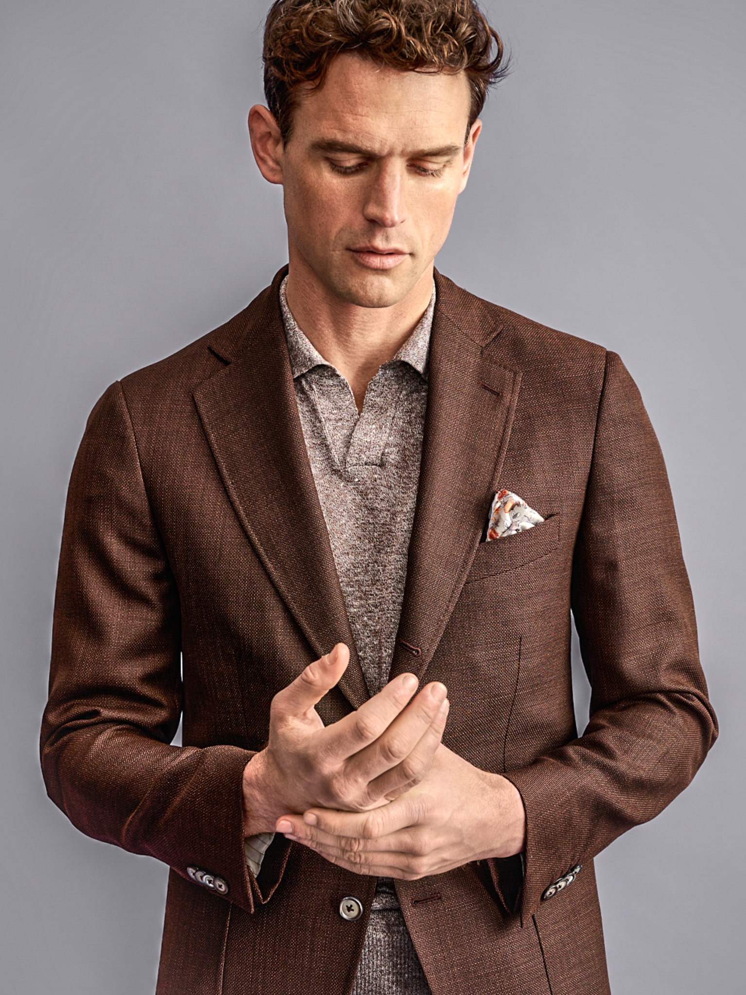 Client in brown solid bespoke sport coat with a casual brown tick knit underneath. Fabric by Ermenegildo Zegna.