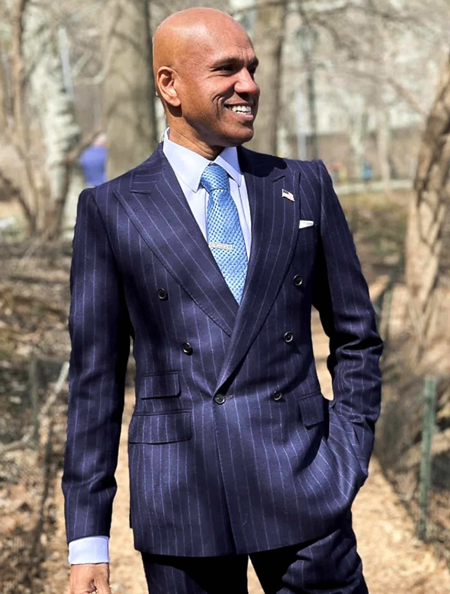 Client in blue double breasted pinstripe suit with white shirt and light blue check tie.