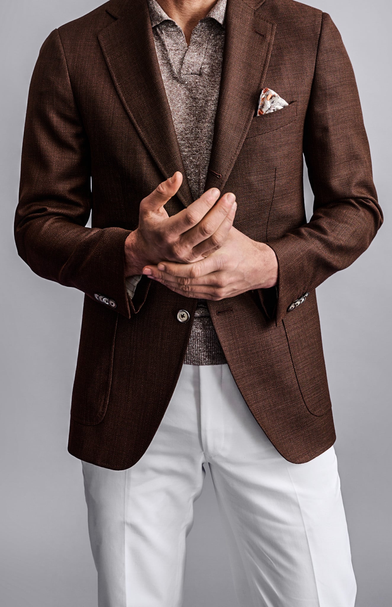 Client wearing solid white Loro Piana custom linen trousers with brown sportscoat and light grey polo knit shirt.