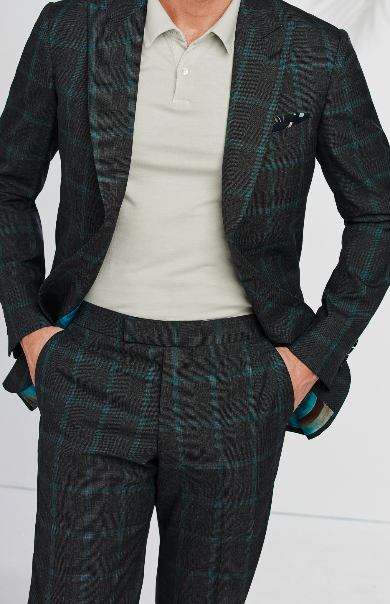 Client showing off charcoal windowpane custom trousers as part of his custom suit.