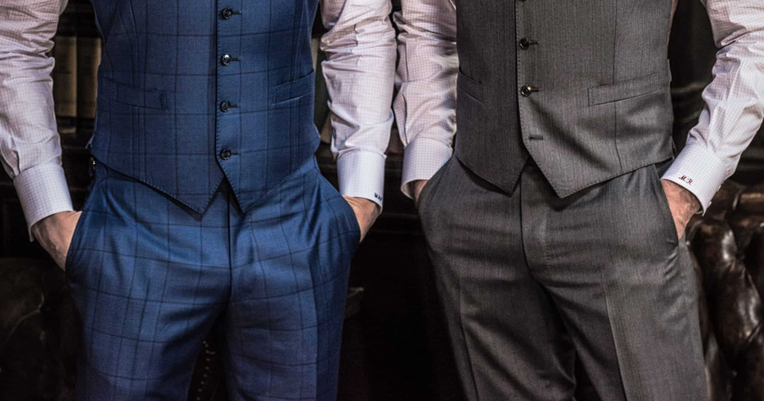 2 models wearing matching custom vests and custom trousers. One in blue windowpane and one in solid charcoal. Fabrics by Vitale Barberis.