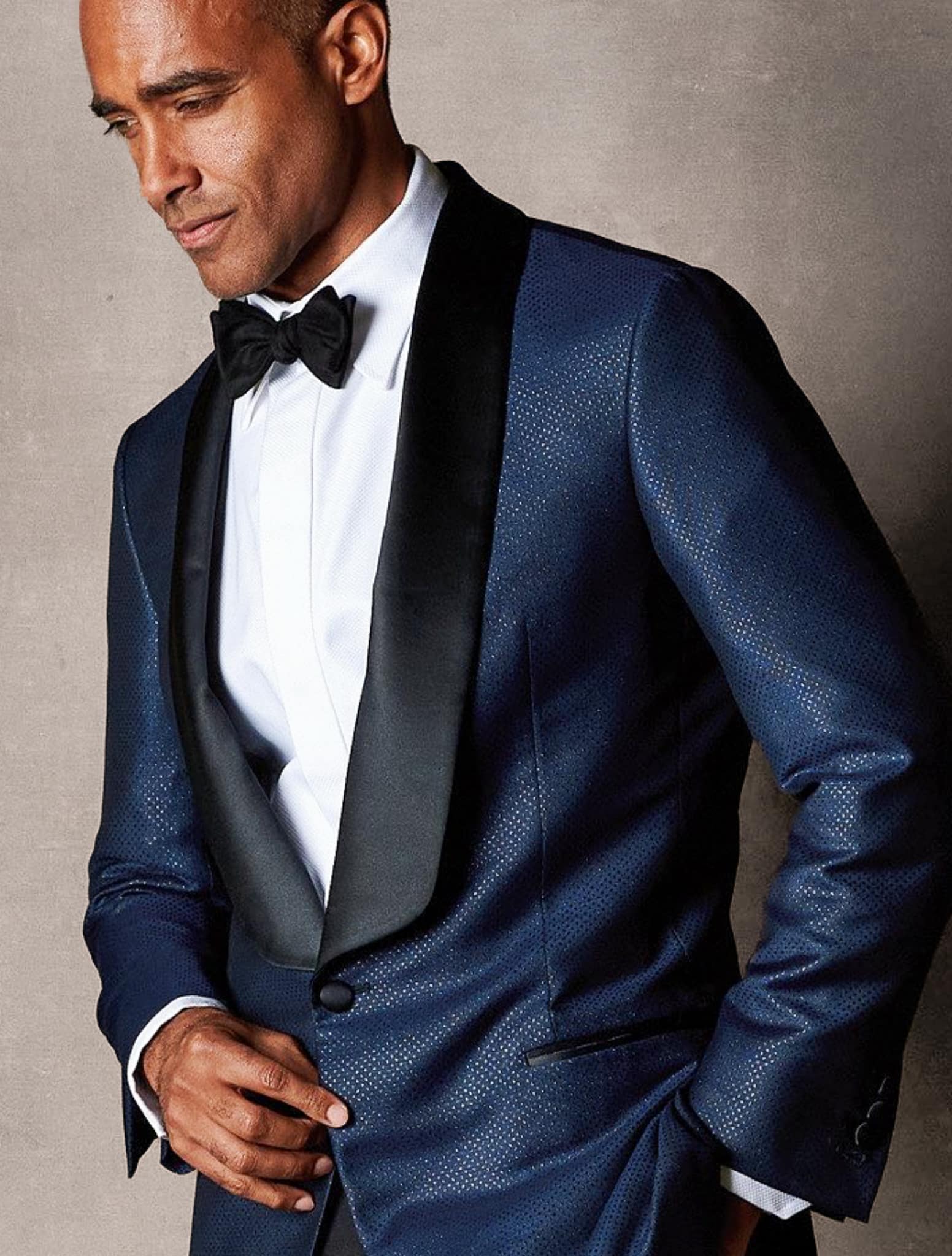 Navy mohair custom tuxedo jacket with low cut in black satin lapel. White shirt and black bowtie.