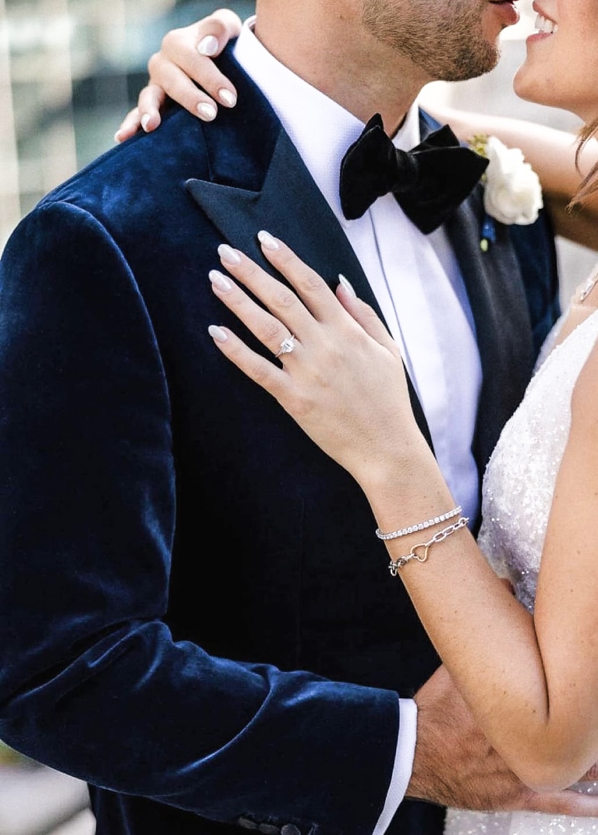 Groom dancing with bride close up. Groom in custom velvet blue custom made tuxedo jacket with navy bowtie. Bride in wedding dress.