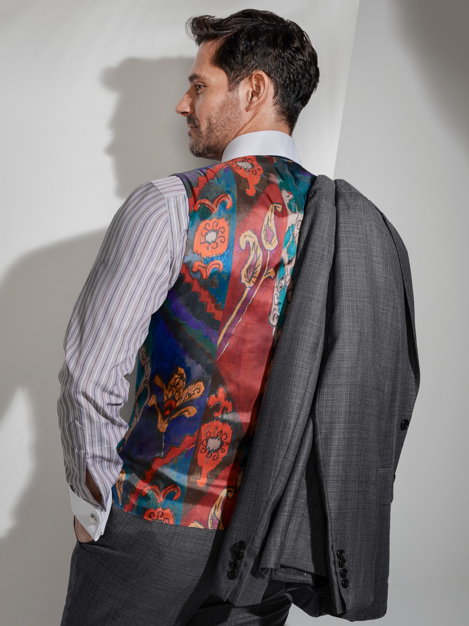 Model showing off back of custom vest lining paisley red and blue design.