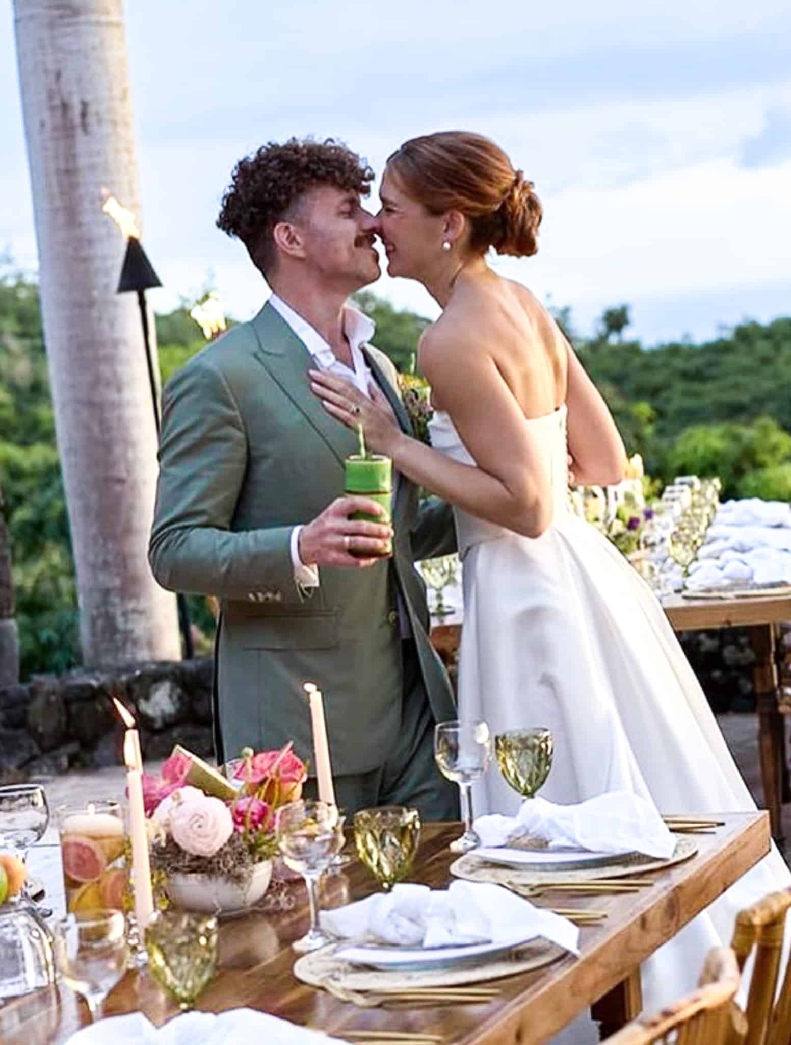 Bride and groom getting ready to kiss. Groom in light green bespoke wedding suit. Bride in wedding gown.