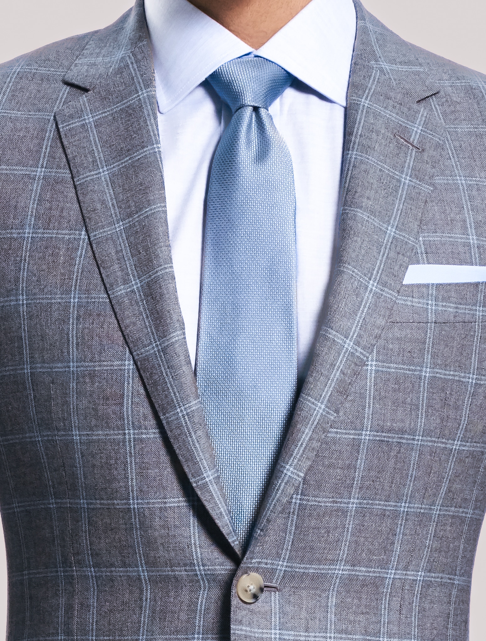 Close up of grooms custom wedding suit. Light grey with white windowpane.