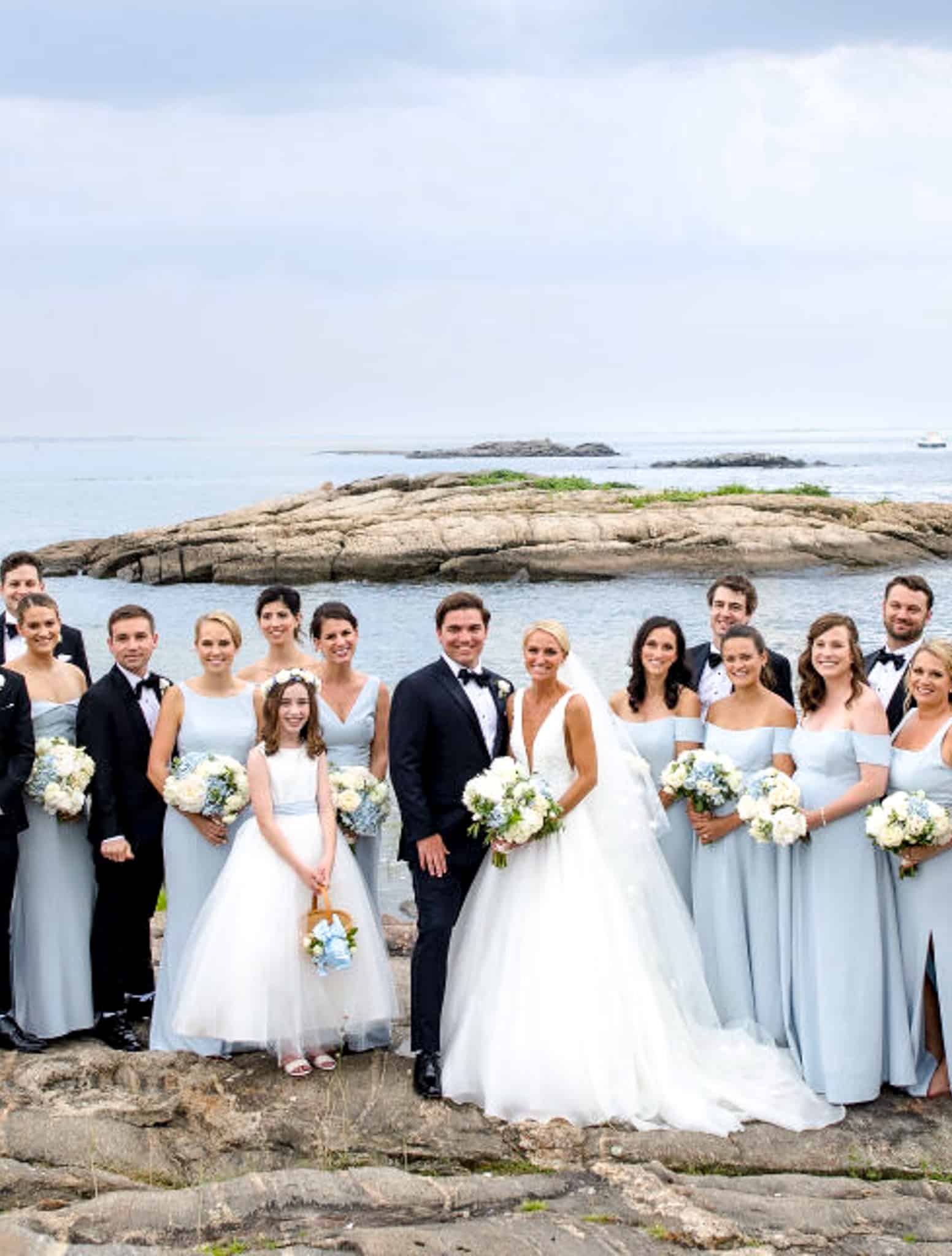 Bride and groom with family, taking pictures in front of the water.