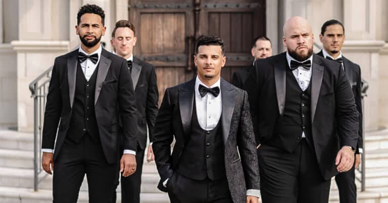 Groom and his five groomsmen standing outside church. All wearing vested custom tuxedos.