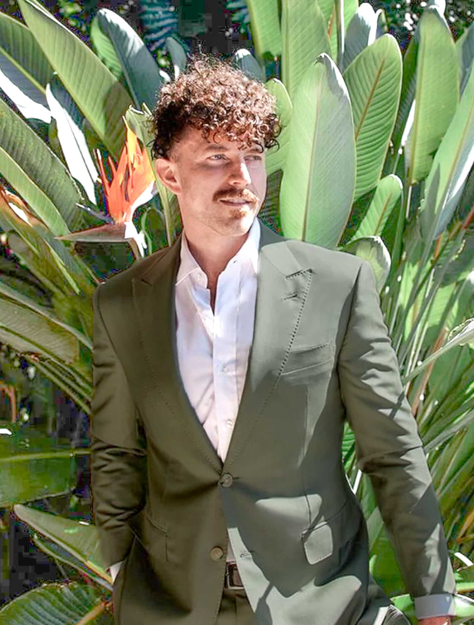 Groom outside in green custom wedding suit.